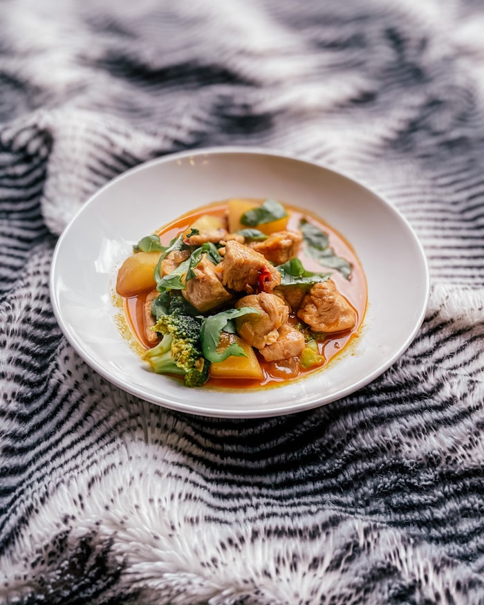 Thai green curry with bamboo shoots and basil on white ceramic